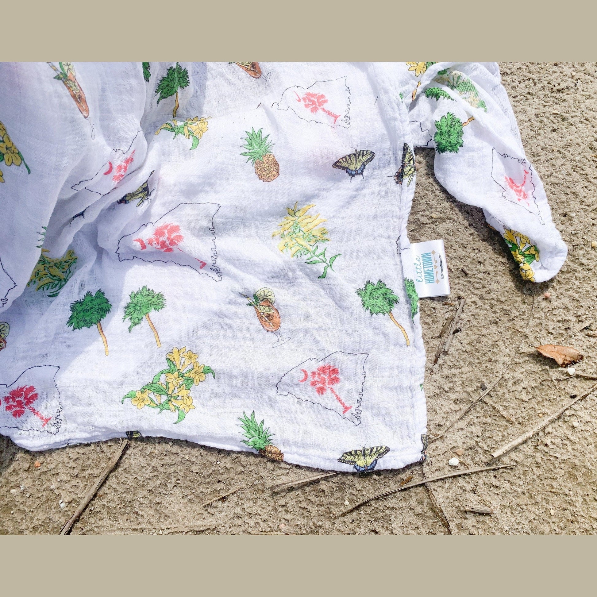 South Carolina-themed baby gift set with muslin swaddle blanket and burp cloth, featuring state icons and text.