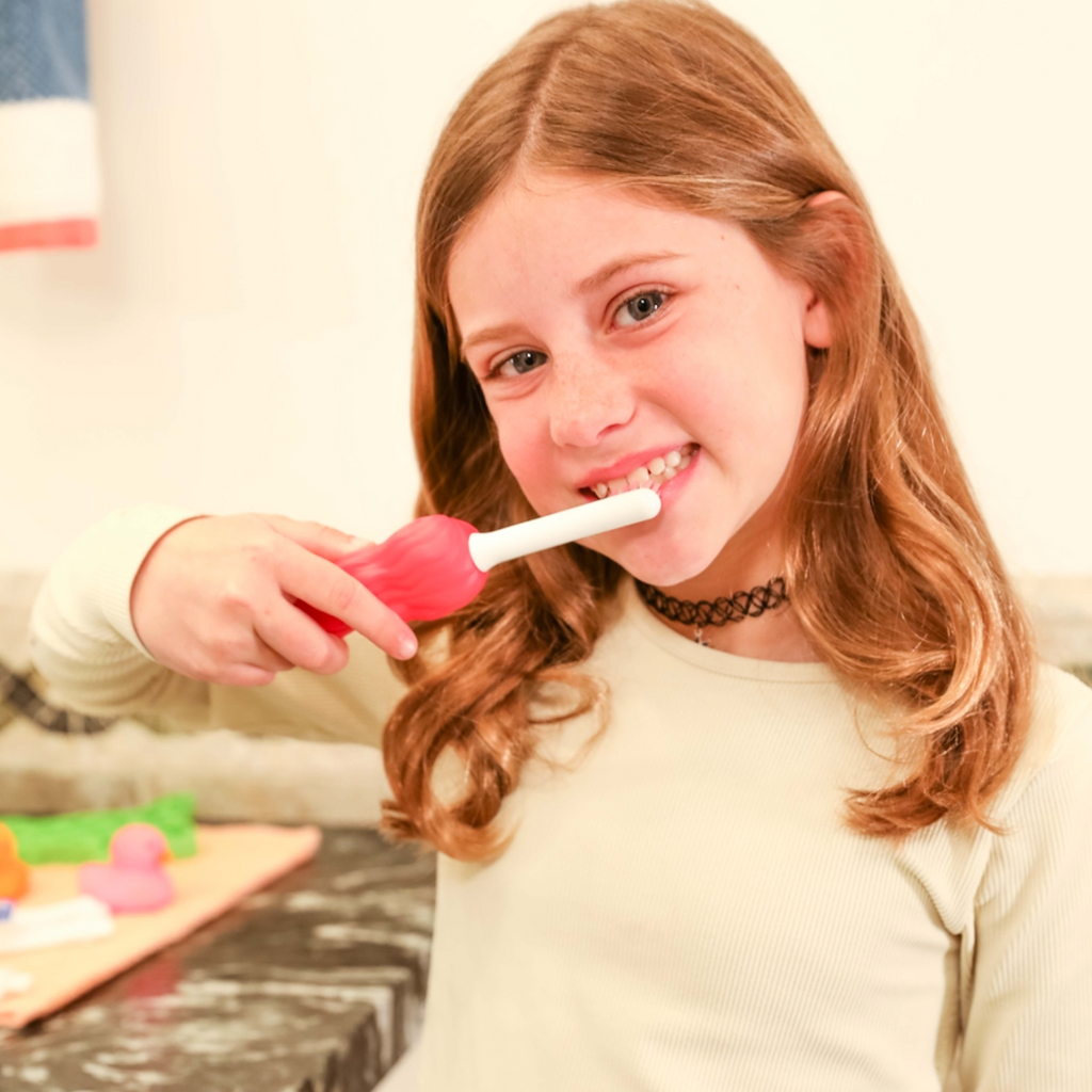Young girl using a mermaid toothbrush for kids with soft bristles to brush her teeth